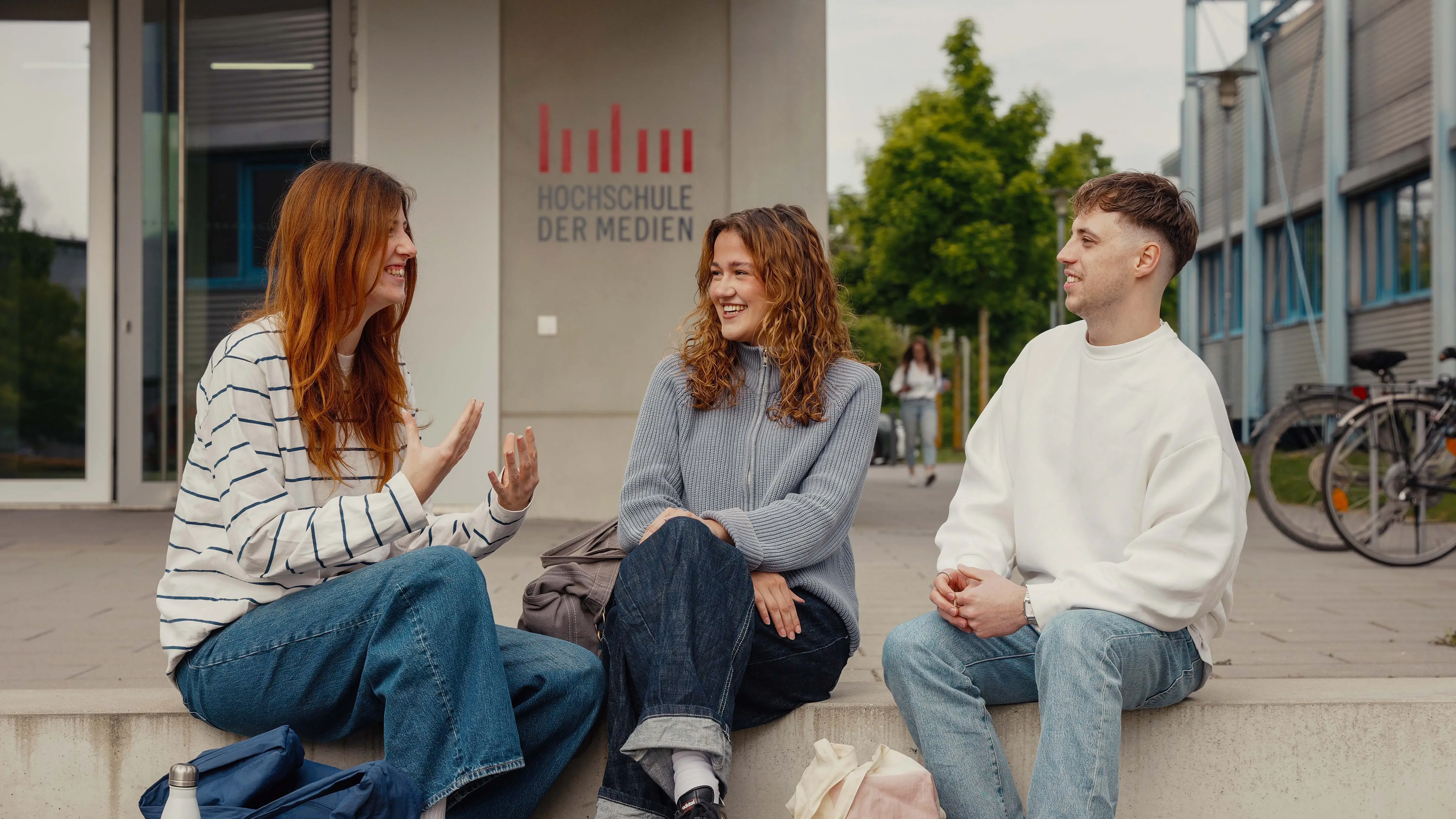 Studierende unterhalten sich vor dem sogenannten Würfel, einem Nebengebäude der Hochschule der Medien.